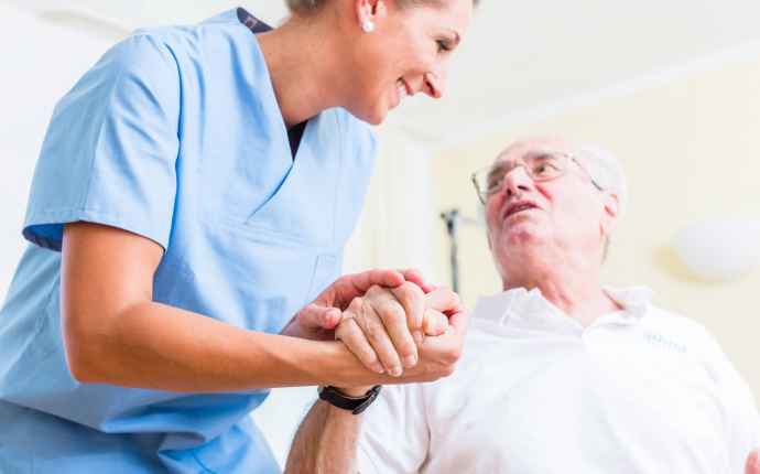 Sköterna håller Parkinsons-patient i handen